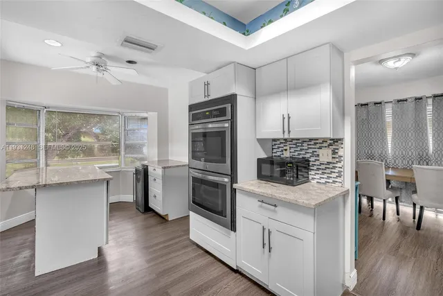 a kitchen with a refrigerator and a stove top oven