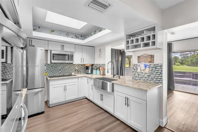 a kitchen with stainless steel appliances granite countertop a stove and cabinets