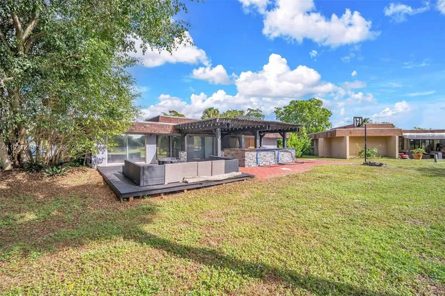 a view of a house with pool and chairs