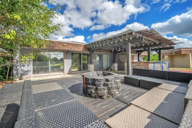 a view of a patio with couches table and chairs and potted plants