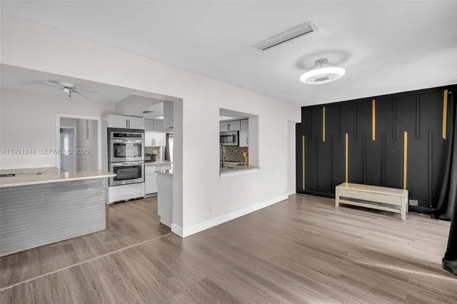 a view of a kitchen with wooden floor and a refrigerator