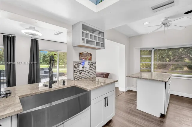 a kitchen with stainless steel appliances kitchen island granite countertop a stove and a sink