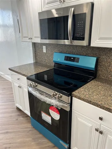 a stove top oven sitting inside of a kitchen