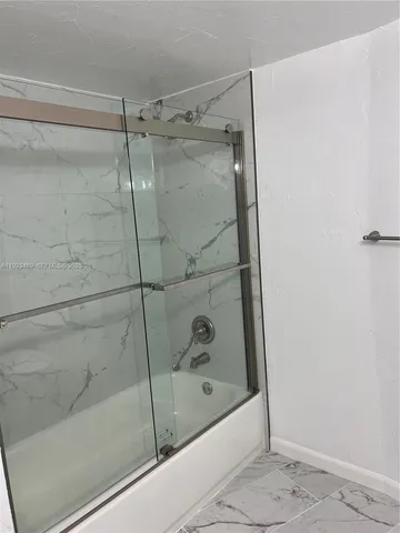 a bathroom with a glass shower door