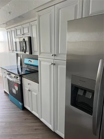 a kitchen with stainless steel appliances granite countertop a refrigerator and a stove