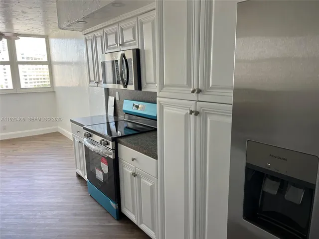 a kitchen with granite countertop a stove and a refrigerator