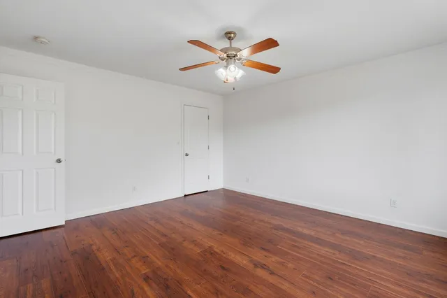a view of an empty room with wooden floor