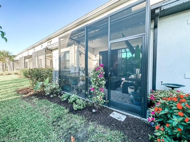 7537 Carnegie Way Naples, FL 34119 - Photo 14 of 35 a view of a front door and flowers