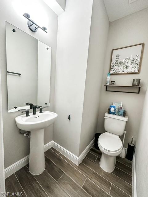 7537 Carnegie Way Naples, FL 34119 - Photo 31 of 35 a bathroom with a toilet sink and mirror