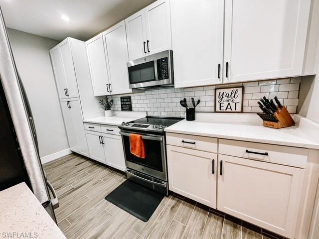 7537 Carnegie Way Naples, FL 34119 - Photo 6 of 35 a kitchen with stainless steel appliances a stove a microwave and white cabinets