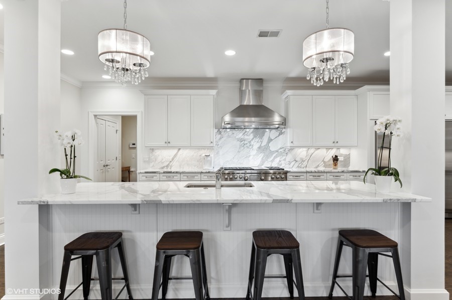 1884 Old Willow Road, Unit 2B Northfield, IL 60093 - Photo 3 of 17 a kitchen with stainless steel appliances granite countertop a table and chairs in it