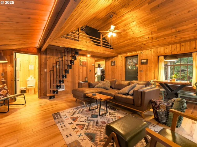 a living room with furniture a wooden floor and next to a window
