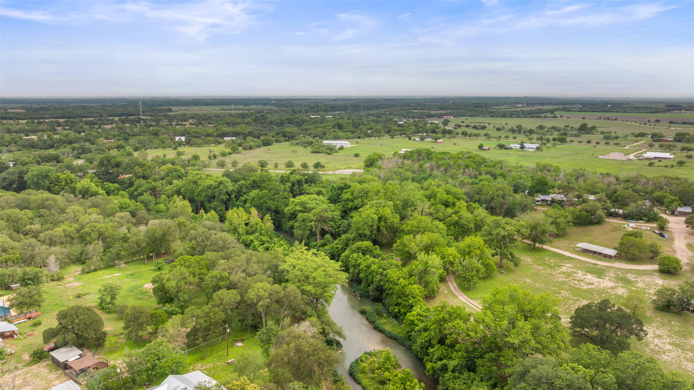 664 Martindale Falls Road Martindale, TX 78655 - Photo 21 of 21 Expansive acreage featuring abundant mature trees, a natural waterway, and distant agricultural fields