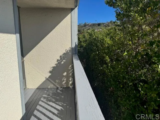 a view of an empty room with wooden floor and bathroom