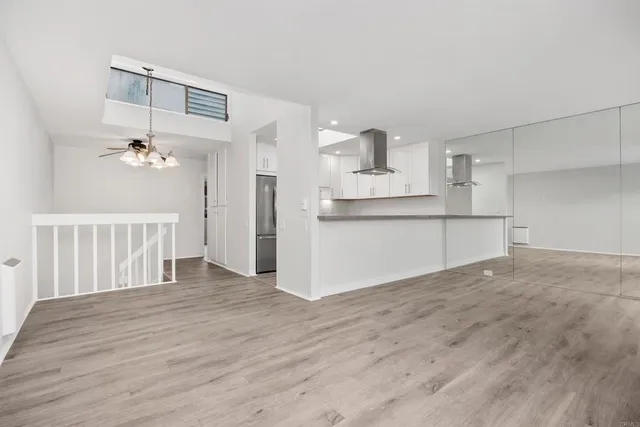 a kitchen with stainless steel appliances granite countertop a refrigerator a sink and white cabinets