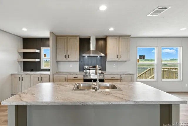 a kitchen with white cabinets stainless steel appliances and a window