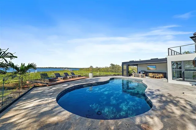 a bedroom with a bed and large windows