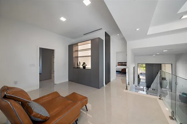 a living room with furniture a flat screen tv and a floor to ceiling window