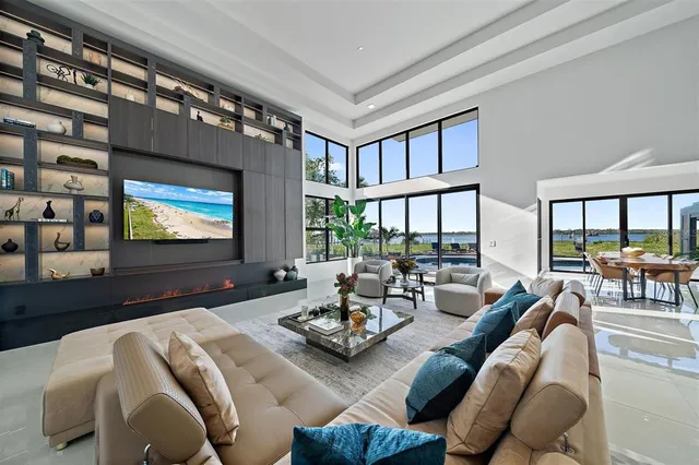 an aerial view of a house with swimming pool and large trees