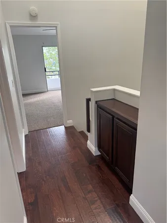 an empty room with wooden floor closet and mirror