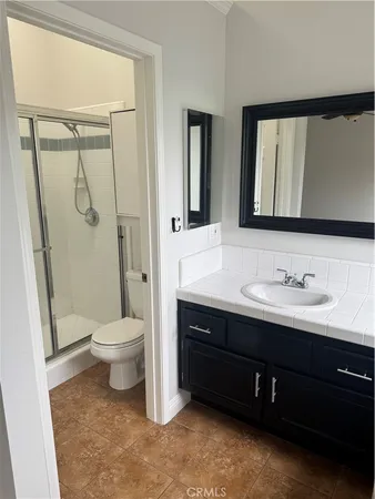 a bathroom with a toilet a sink a mirror a vanity and window