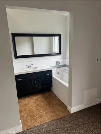 a bathroom with a tub sink and mirror