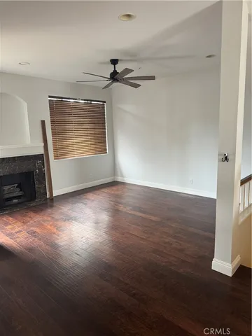 an empty room with wooden floor cabinet and windows