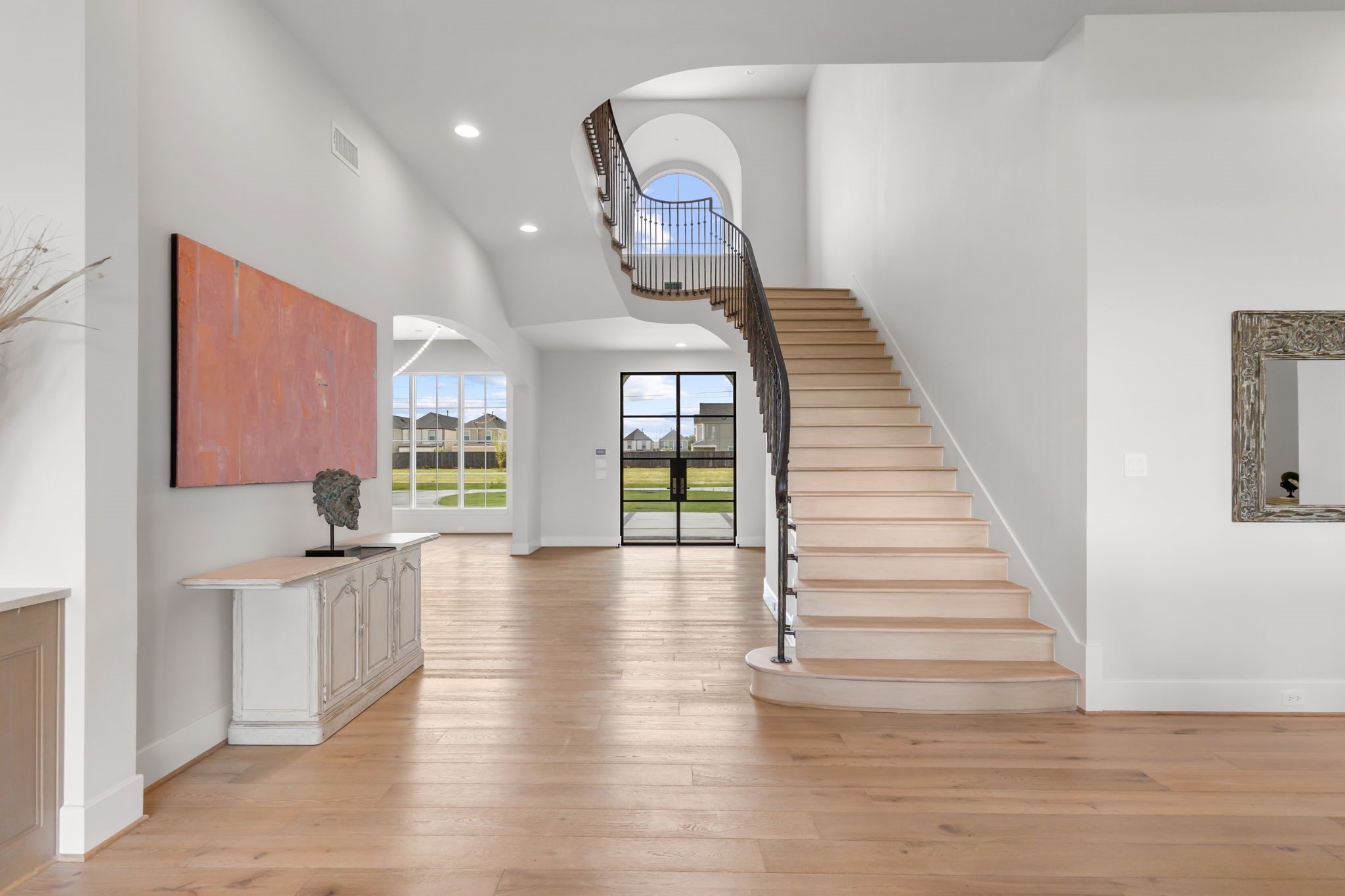 4233 Two Gun Way Katy, TX 77494 - Photo 2 of 47 View straight into the grand entry foyer with sweeping stair case. The formal dining is the left through the curved arch.