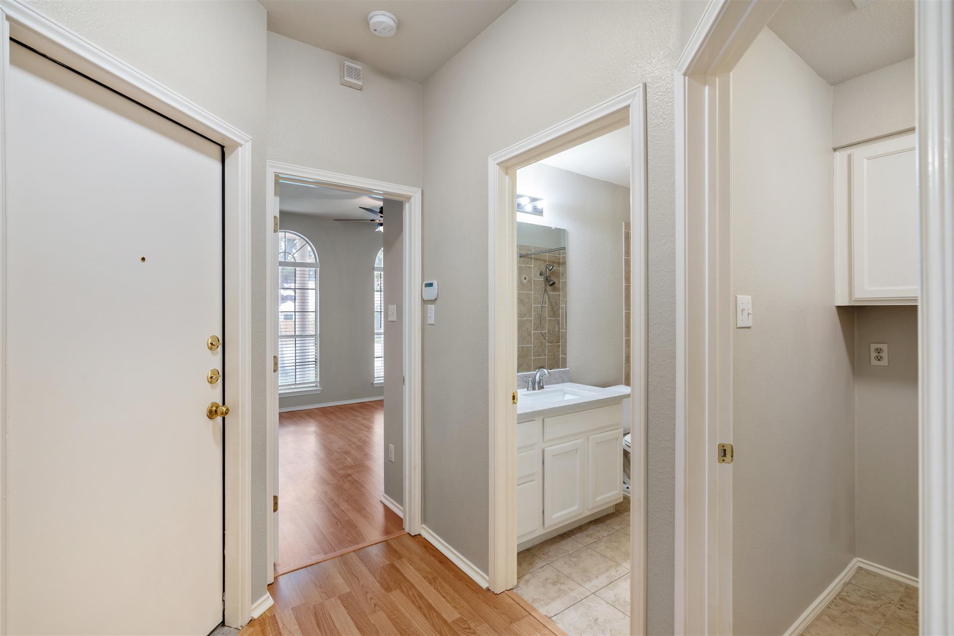 4725 Tello Path Austin, TX 78749 - Photo 29 of 34 A welcoming entryway with gleaming wood floors flows into the living area, while a well-appointed bathroom offers convenient access.