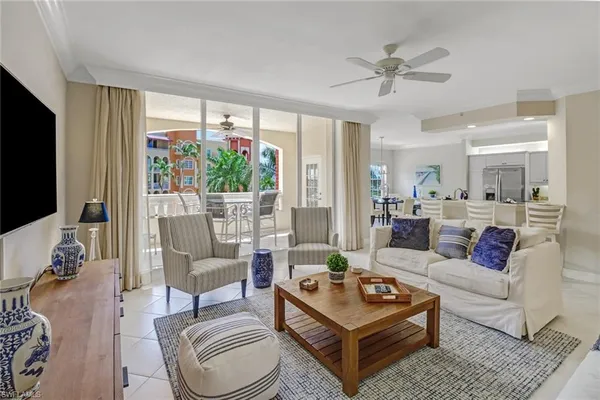 a living room with furniture a flat screen tv and a large window