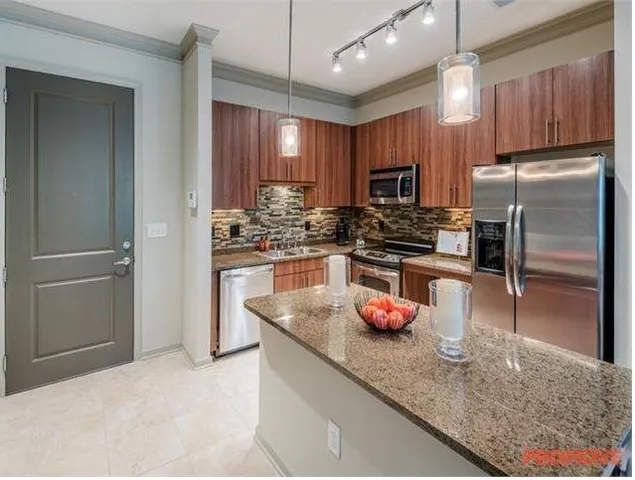 a kitchen with granite countertop a refrigerator and a sink