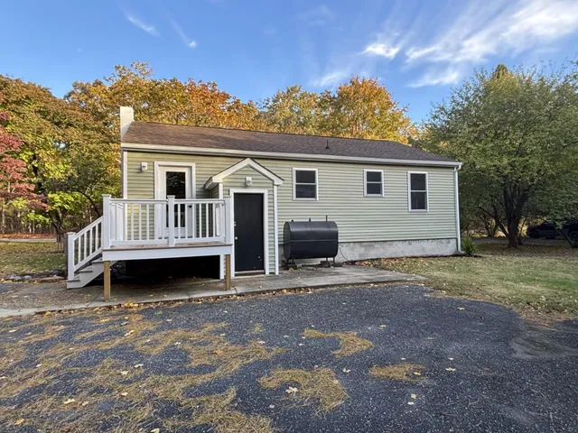 a view of a house with a yard and sitting area