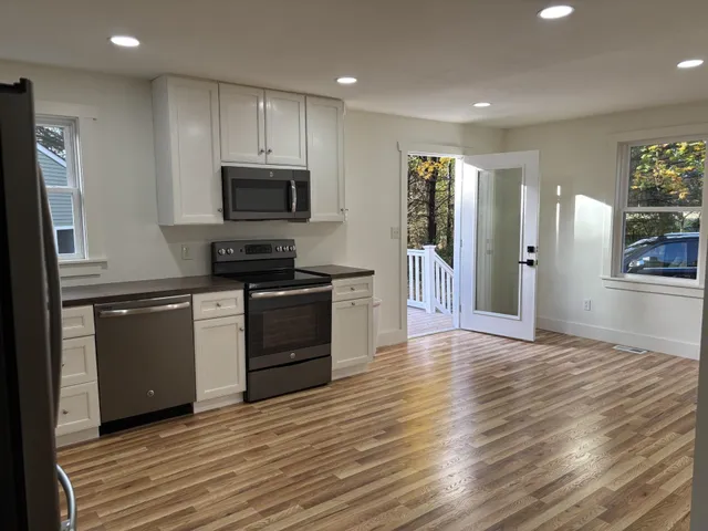 a kitchen with granite countertop a refrigerator and a stove top oven