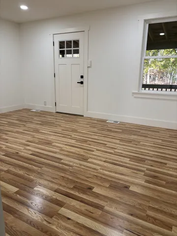 a view of a room with wooden floor and windows