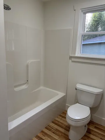 a white toilet sitting next to a tub