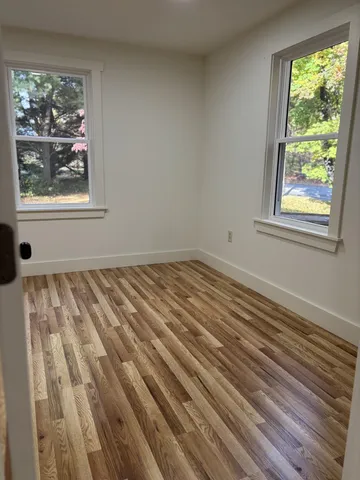 a view of a room with wooden floor and windows