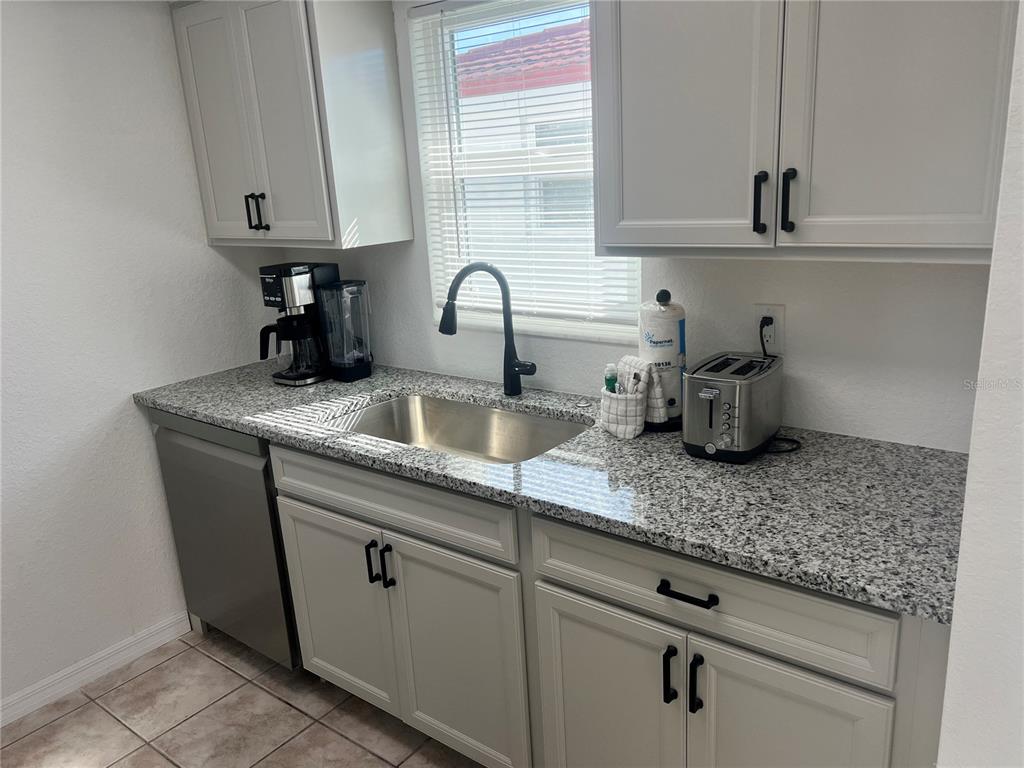 6154 Midnight Pass Road, Unit B03 Sarasota, FL 34242 - Photo 2 of 11 a kitchen with sink and cabinets