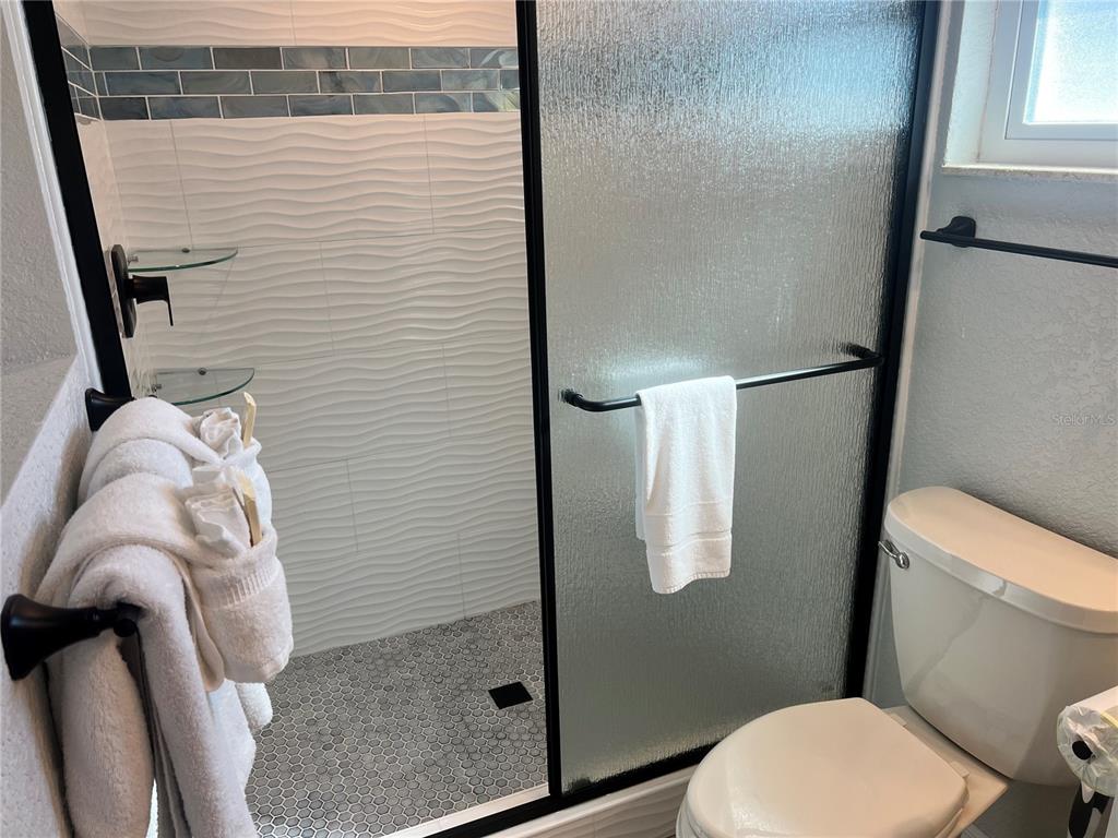 6154 Midnight Pass Road, Unit B03 Sarasota, FL 34242 - Photo 7 of 11 a bathroom with a toilet and a shower
