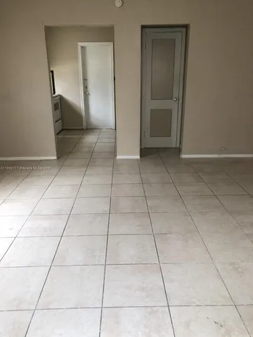 a view of a livingroom with an empty space and a window