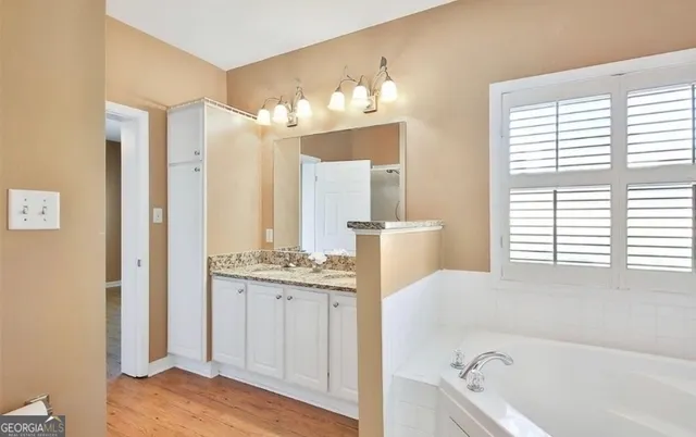 a bathroom with a tub sink and a mirror