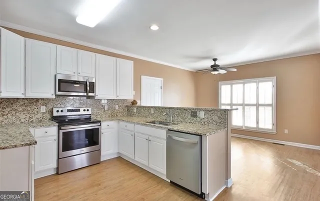 a kitchen with stainless steel appliances granite countertop a stove and a sink