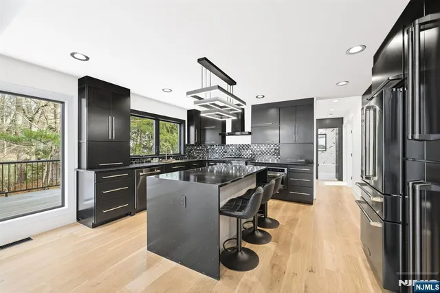 a kitchen with kitchen island a counter top space a sink stainless steel appliances and cabinets