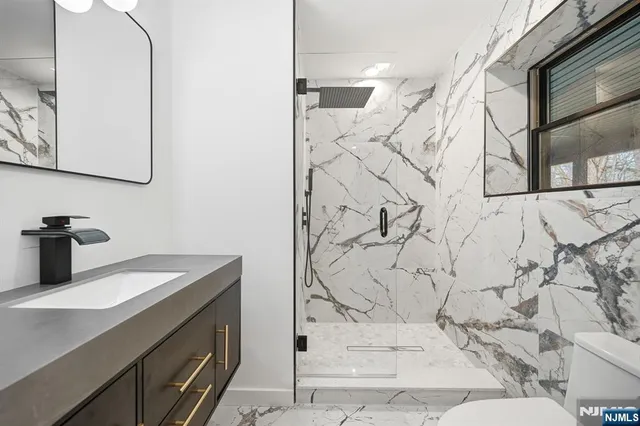 a bathroom with a sink and mirror with bathtub