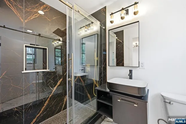 a bathroom with a sink a toilet and a mirror