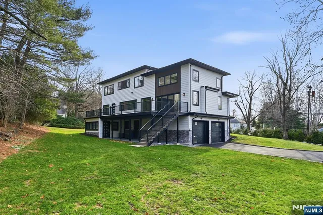 a view of a house with a big yard with large trees