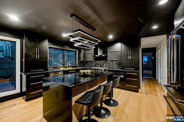 a kitchen with kitchen island a counter top space a sink stainless steel appliances and cabinets