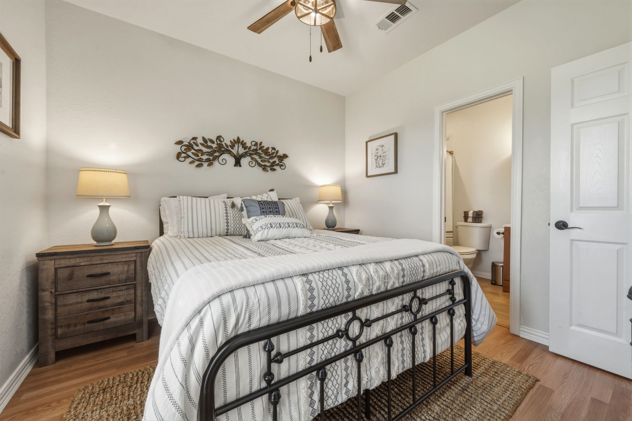 1516 Old Luling Road Lockhart, TX 78644 - Photo 15 of 39 Bedroom with light wood-style flooring, a ceiling fan, and ensuite bathroom