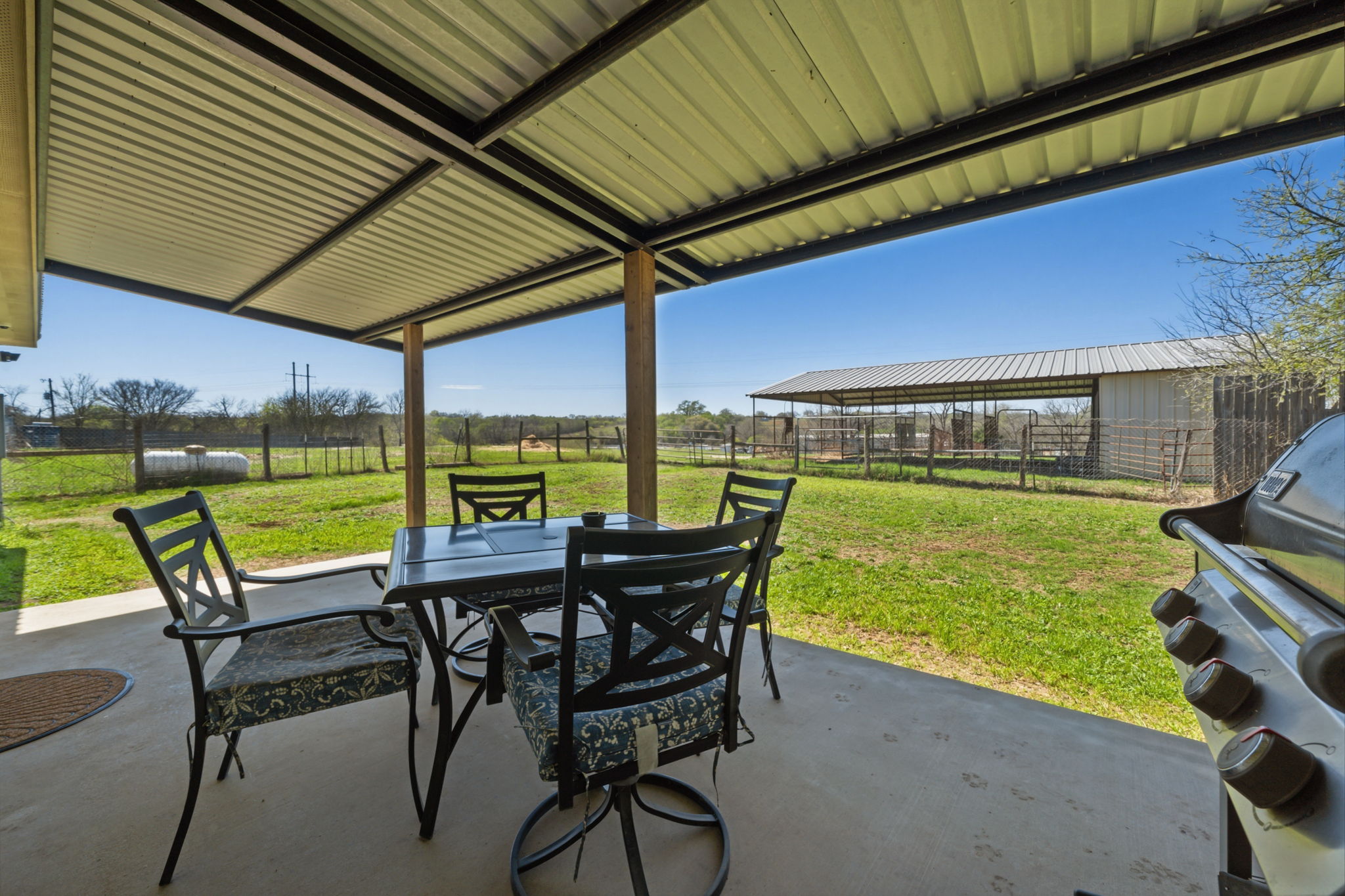 1516 Old Luling Road Lockhart, TX 78644 - Photo 22 of 39 Fenced backyard with outdoor dining space, a patio, a grill, Barn with Sunset views