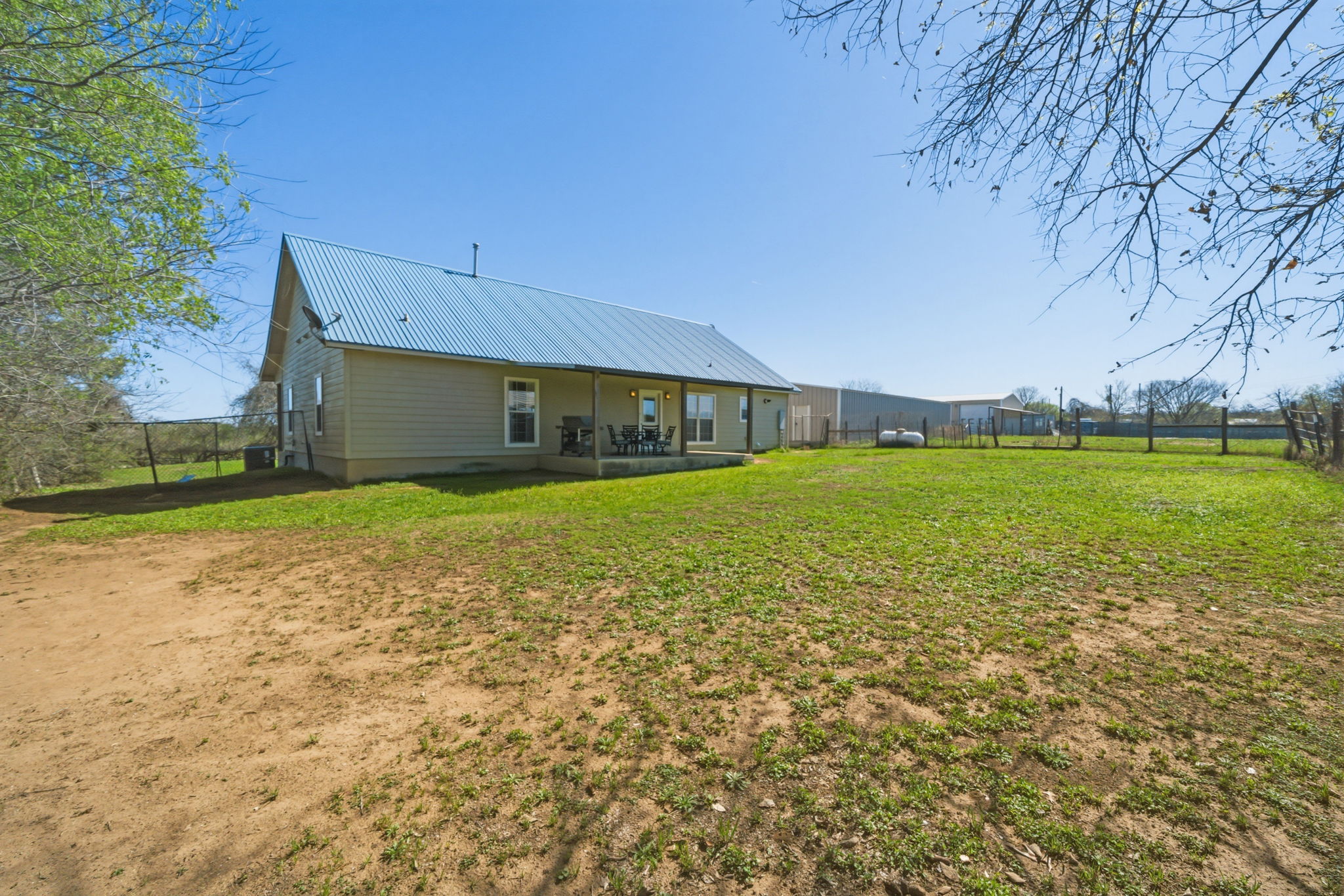 1516 Old Luling Road Lockhart, TX 78644 - Photo 24 of 39 Back of property featuring a fenced backyard, a patio, and a metal roof