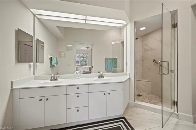 a bathroom with a double vanity sink mirror and shower